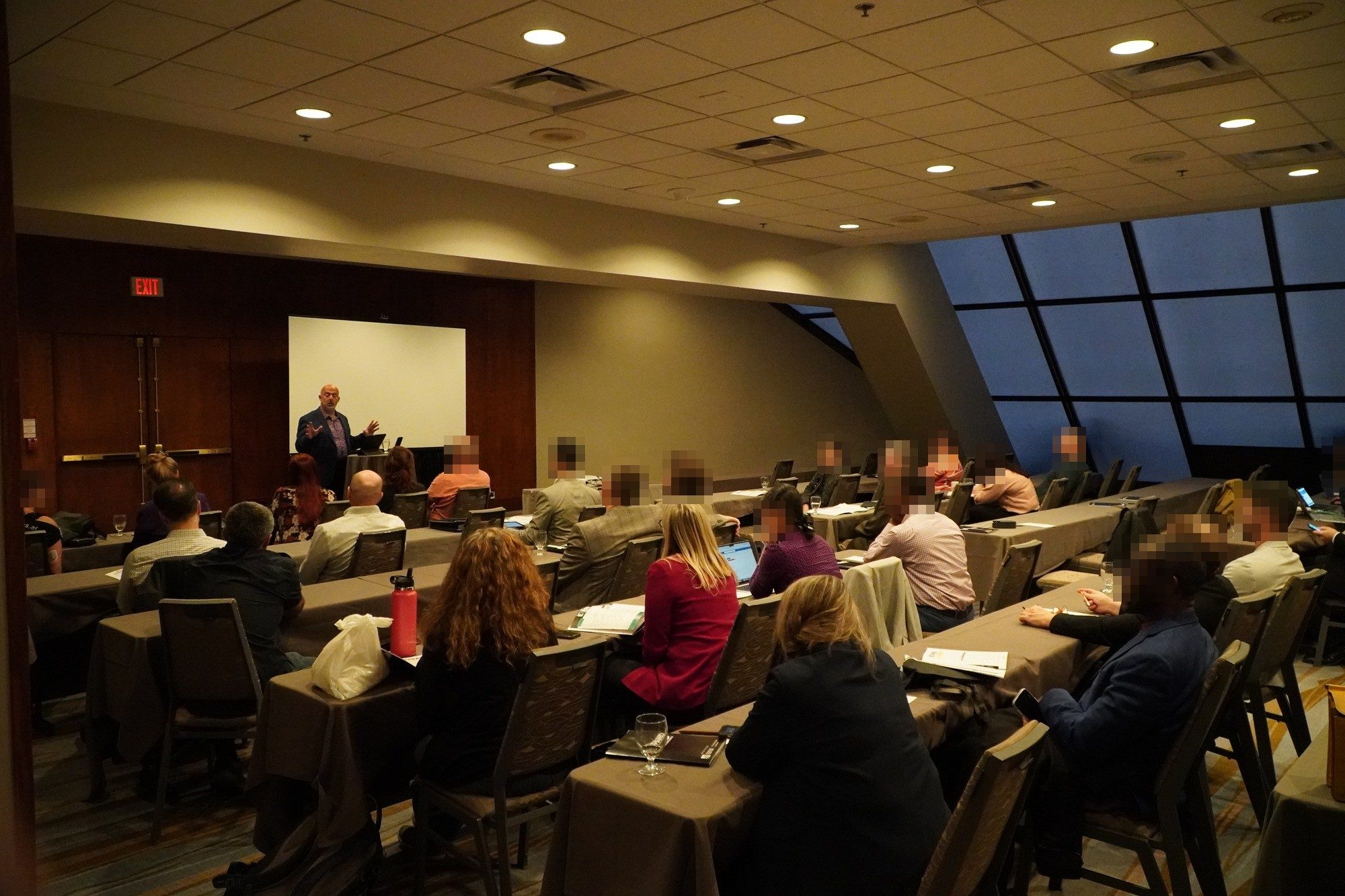 A full seminar room in Toronto seen from the back, with Jose Salloum presenting at the front