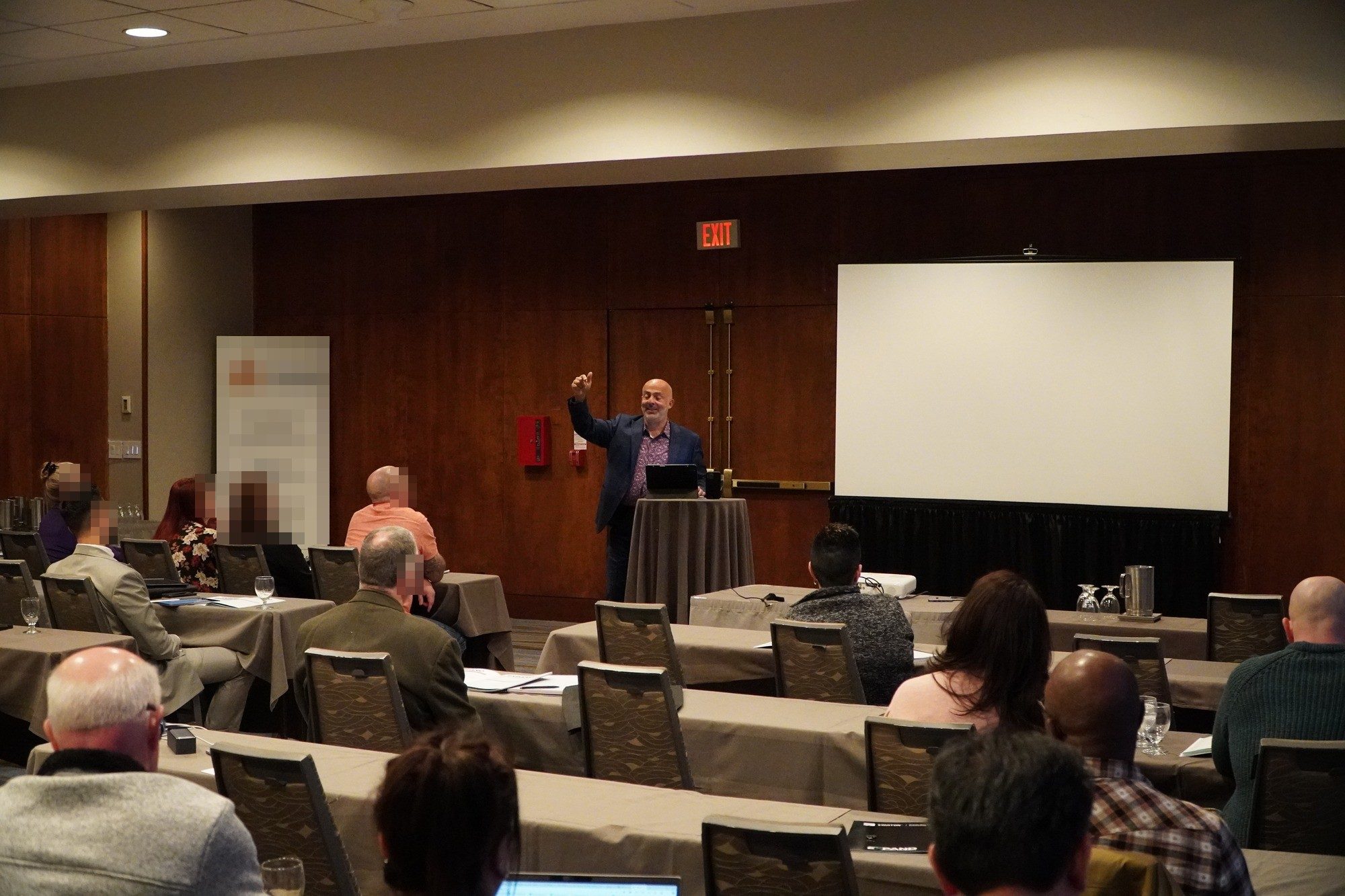 Jose Salloum presenting from a lectern to a seminar audience in Toronto